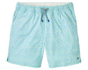 The Peter Millar Tide Lines Swim Trunk features a light blue and green pattern, elastic drawstring waistband, quick-drying fabric, side slits, mesh liner for comfort, and a small circular logo near the hem.