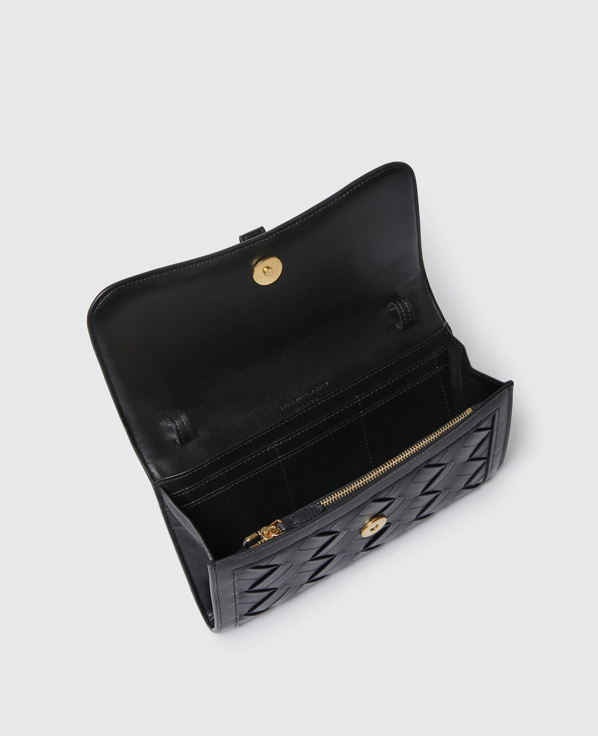 The Stella McCartney Stella Woven Ryder Wallet with Strap features a black quilted exterior, woven design, zippered pocket, card slots, and gold snap closure, combining style and functionality inspired by classic elegance.