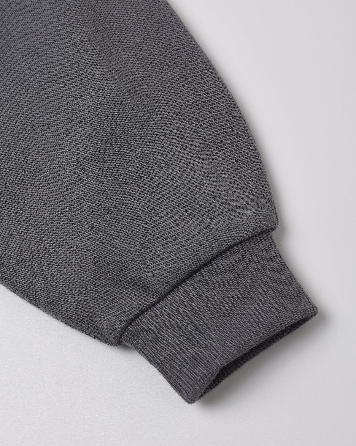 Close-up of a gray sweatshirt sleeve with ribbed cuff, displayed on a white background—a perfect complement to the Quincy Mae Baby Boys’ and Boys’ Sweatpant.