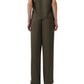 A person stands with their back to the camera, wearing Simkhai’s Kyra Wide Leg Pant in dark olive green satin with a tailored waistband and matching short-sleeve top for a relaxed silhouette.