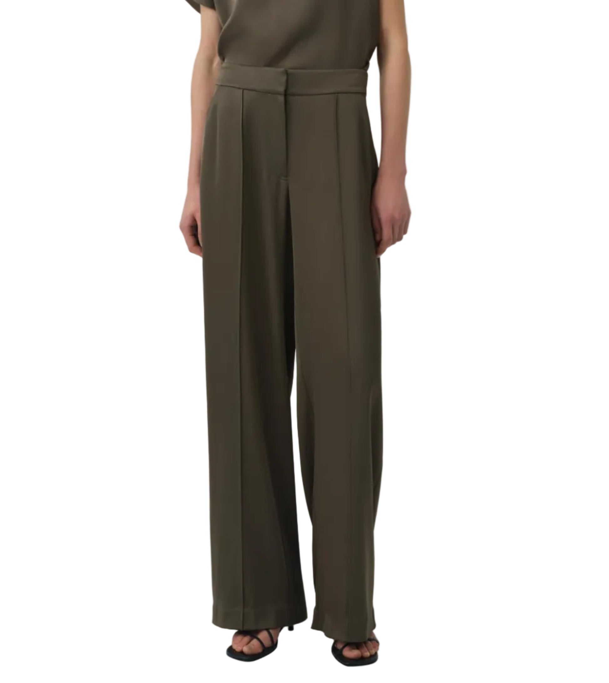 Wearing the Simkhai Kyra Wide Leg Pant in olive green with a tailored waistband and pleats, styled with a matching top and black open-toe heels for a polished yet relaxed look.