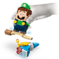 A gloved hand holds the LEGO® Super Mario™ Adventures with Interactive LEGO® Luigi™ by Legos - Toyhouse, featuring Luigi on a broomstick above a blue character—an ideal gift for Nintendo fans and unique LEGO collectors.