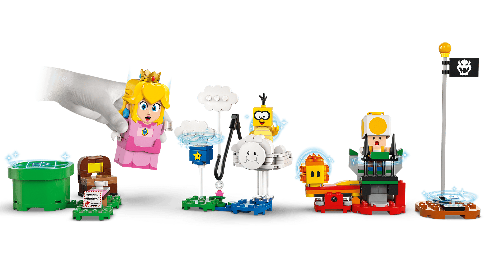 A hand places the LEGO® Peach™ figure from the LEGO® Super Mario™ Adventures with Interactive LEGO® Peach™, by Legos - Toyhouse, among colorful Super Mario elements like a green pipe, characters, and a flagpole.