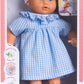 The Corolle Premier Calin - Milly Doll is a soft-bodied baby doll dressed in a blue gingham dress and white headband, displayed in its box featuring product details and a child holding the doll.