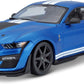 The 1:18 SE 2020 Mustang Shelby GT500 by Maisto is a striking die-cast model car featuring a blue finish with white racing stripes, black wheels, rear spoiler, and black hood vent—shown here from a front-side angle, it’s the perfect collectible for car enthusiasts.