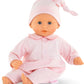 The Corolle Bebe Calin - Charming Pastel 12" baby doll features blue eyes, a pink outfit with matching hat, and a soft body—ideal as a first doll for little ones.
