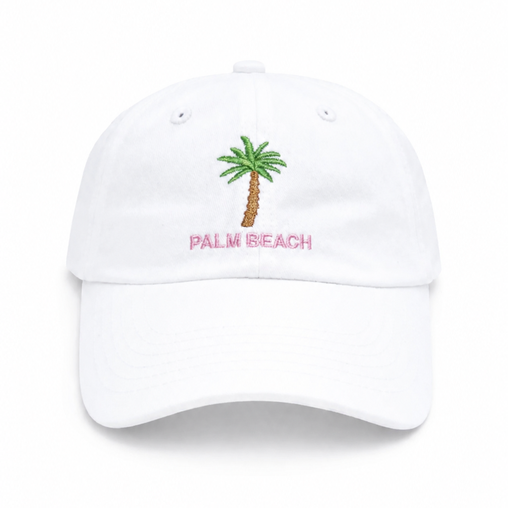 The Bits & Bows Palm Beach Hat is a girls’ white baseball cap featuring an embroidered green palm tree with “PALM BEACH” in pink lettering centered on the front—a fun and stylish accessory that adds a pop of color to any outfit.