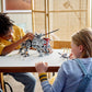 Two children are deeply engrossed in assembling their LEGO® Star Wars AT-TE Walker, carefully constructing each intricate piece from the set by Legos - Toyhouse, as scenes from Star Wars: Revenge of the Sith come to life in their imagination.