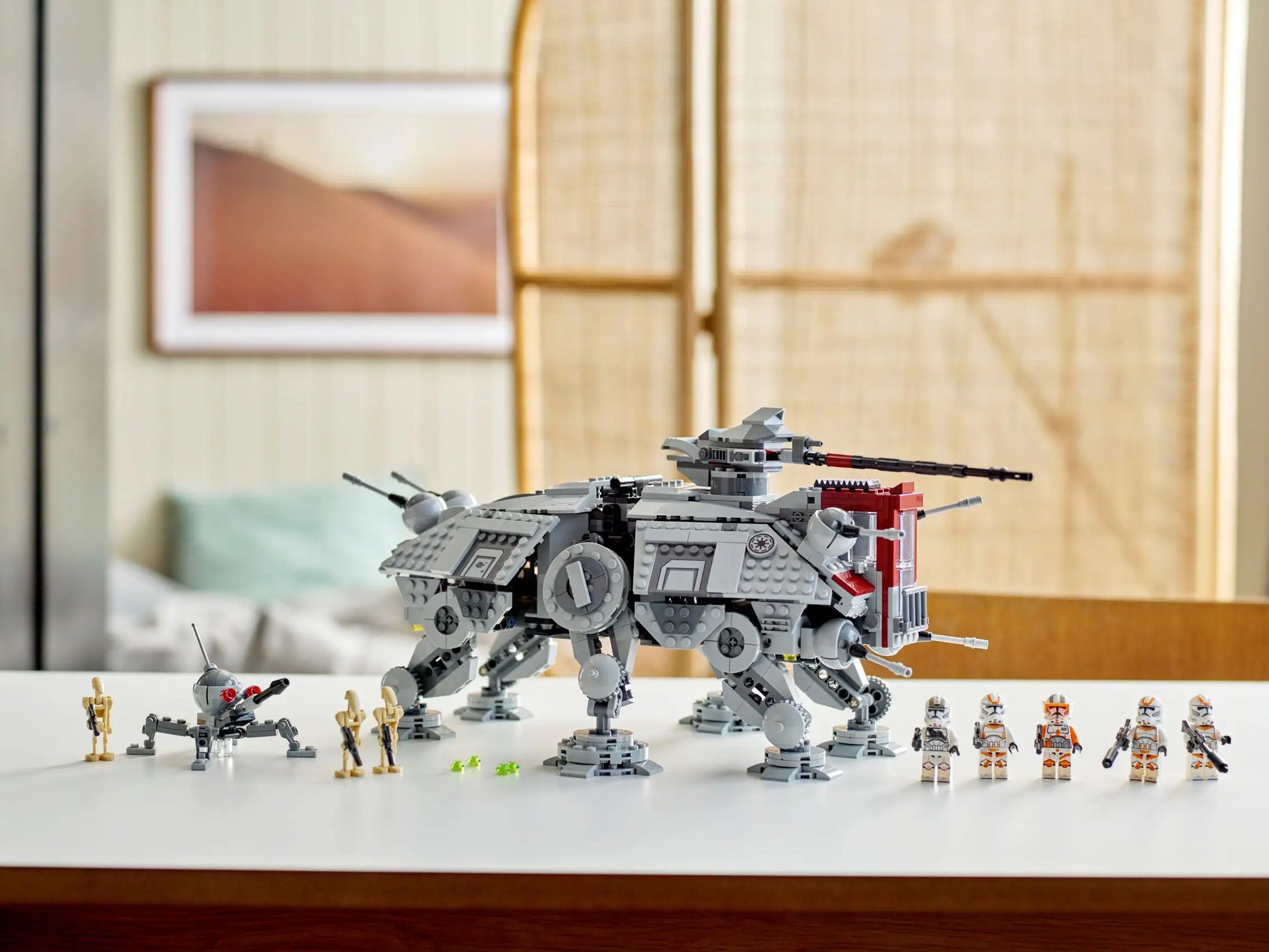 A LEGO® Star Wars AT-TE Walker from Legos - Toyhouse is prominently displayed on a white table, surrounded by a number of LEGO minifigures.
