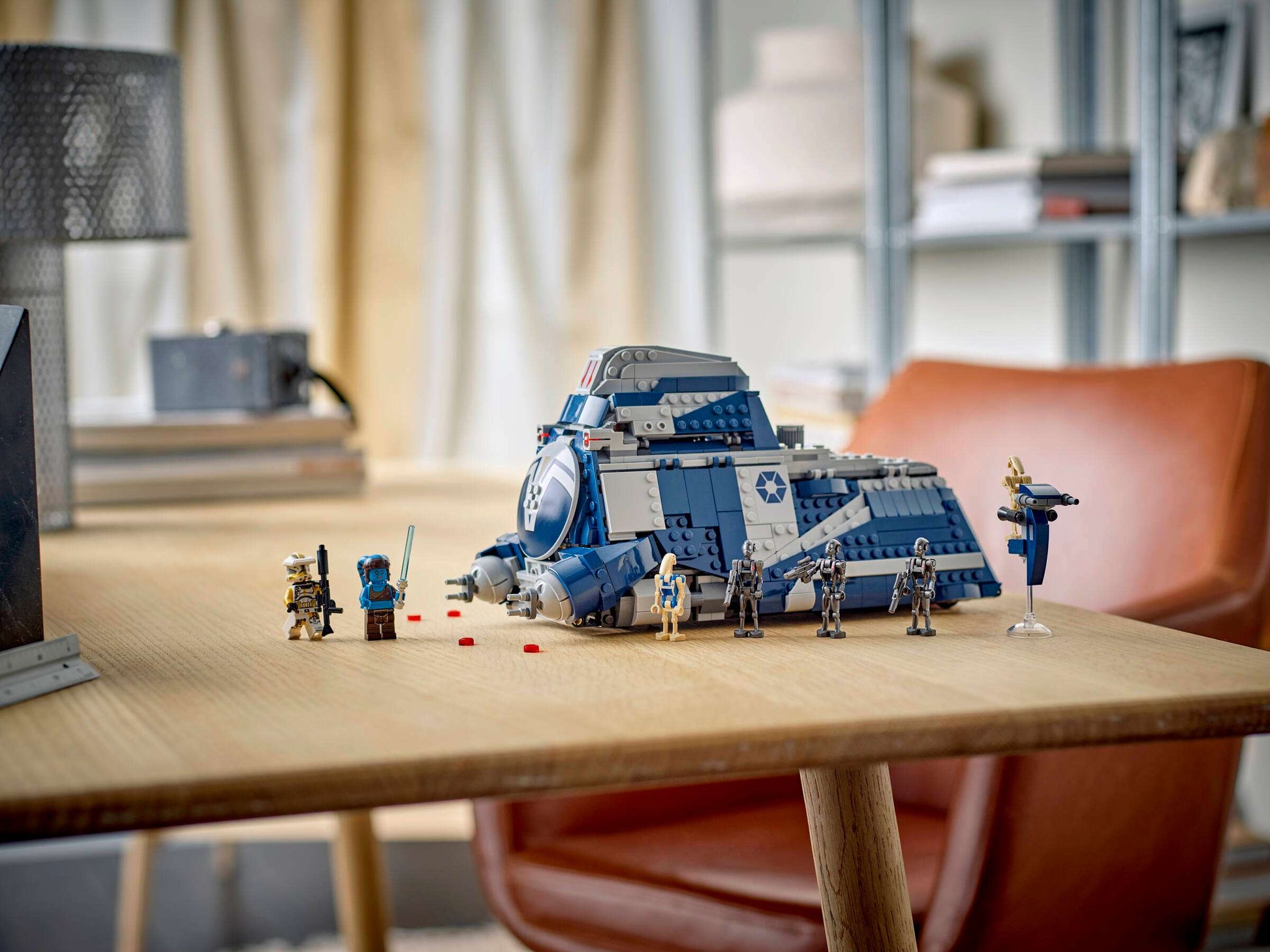 The Legos - Toyhouse LEGO® Star Wars™ Battle of Felucia Separatist MTT™ set, with minifigures and a blue-gray MTT, is displayed on a wooden table in a bright room, perfect for reenacting the epic battle.