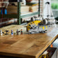 The Legos - Toyhouse LEGO® Star Wars™ The Razor Crest™ set and six minifigures are displayed on a wooden table in a bright room with shelves and a window in the background.
