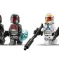 Four minifigures from the LEGO® Star Wars™ Siege of Mandalore Battle Pack by Legos - Toyhouse, including two gray-armored Mandalorians with weapons and two white-and-orange Clone Troopers, are ready for battle on a white background.