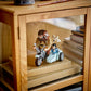 The LEGO® Harry Potter™ Hagrid™ & Harry's Motorcycle Ride set from Legos - Toyhouse is displayed in a wooden glass cabinet, next to stacked books and boxes.