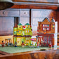 The LEGO® Harry Potter™ Quality Quidditch™ Supplies & Ice Cream Parlour set by Legos - Toyhouse, featuring minifigures, is displayed on a green surface with wooden furniture and drawers in the background.