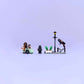 Four LEGO® Harry Potter™ minifigures and accessories, including a streetlamp and plants, are set on a light purple background—perfect for recreating Privet Drive escape scenes with Hagrid’s motorcycle from Legos - Toyhouse.