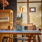 A LEGO® Harry Potter™ Hogwarts™ Castle: Hospital Wing set by Legos - Toyhouse is displayed on a table in a cozy room with wooden shelves filled with books and decorative items in the background.