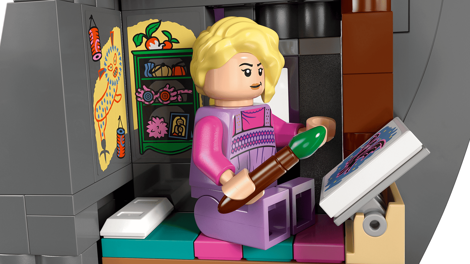 A LEGO® Harry Potter™ Luna Lovegood’s House set by Legos - Toyhouse features a blonde figure painting at a desk in a detailed, decorated room inspired by Luna’s enchanting home—perfect for imaginative play.
