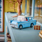 The LEGO® Harry Potter™ Enchanted Flying Ford Anglia™ by Legos - Toyhouse, along with a small brown box, is displayed on a light blue shelf near books and a window.
