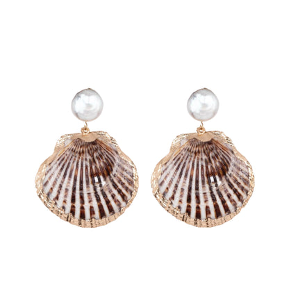 The Jennifer Behr Folly Earrings showcase round crystal pearl studs with gold-rimmed brown natural seashell pendants, elegantly displayed on a white background.