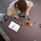 Someone assembles Legos - Toyhouse LEGO® Speed Champions Lamborghini Revuelto & Huracán STO sets with small parts on a table, following instructions displayed on an open tablet nearby.