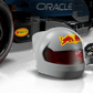 A close-up of the LEGO® Speed Champions Oracle Red Bull Racing RB20 F1® Race Car by Legos - Toyhouse, featuring a gray helmet with a red visor and a black controller with colorful buttons and displays.