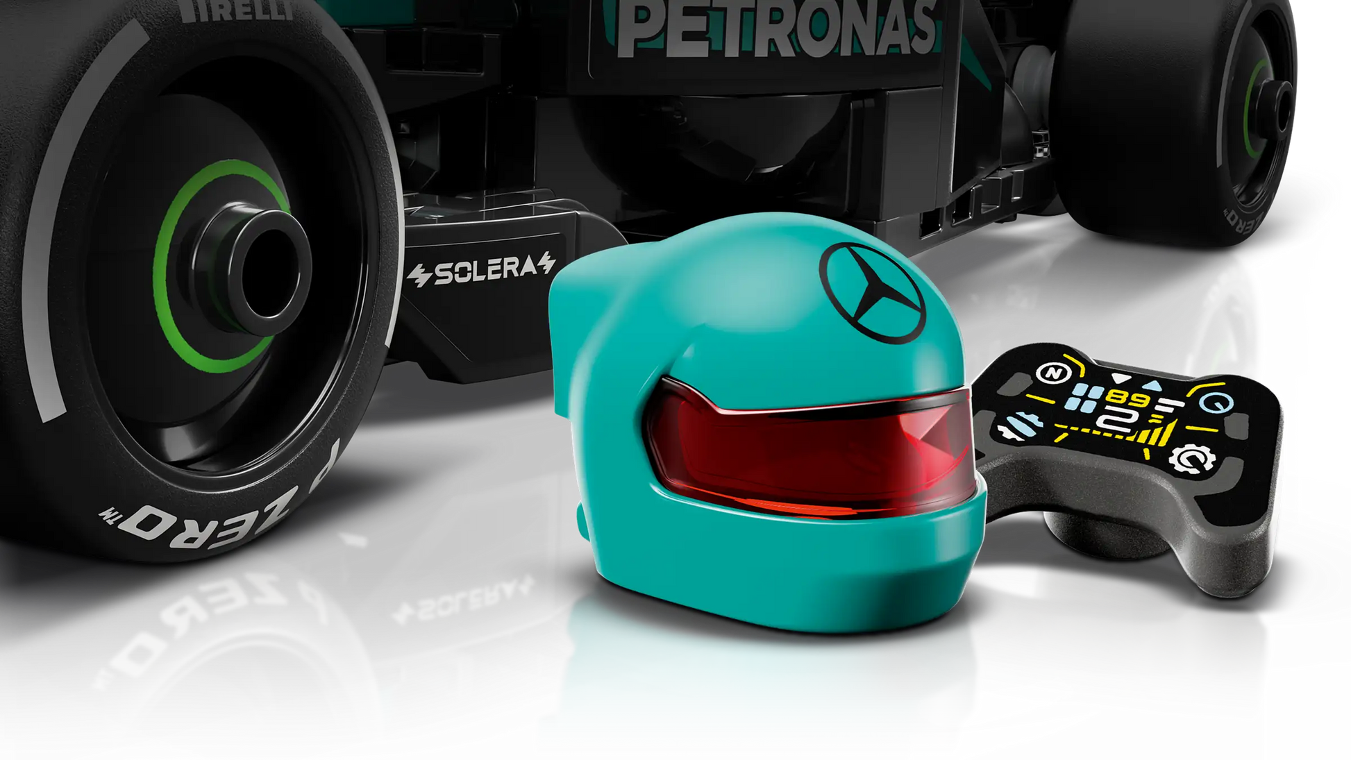 Close-up of a LEGO® Speed Champions Mercedes-AMG F1® W15 Race Car wheel, a teal Mercedes-AMG PETRONAS helmet, and a black remote with digital display, from Legos - Toyhouse.