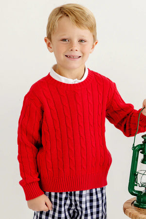 Young boy with blonde hair wears The Beaufort Bonnet Company’s Baby and Kids' Crawford Crewneck in Richmond Red and checkered shorts, standing and holding a green lantern—a classic, timeless look.