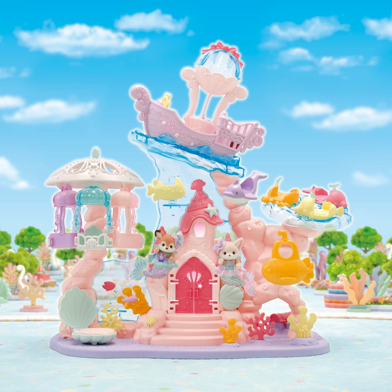 Create your own sea-themed amusement park adventure with the Calico Critters Baby Mermaid Castle playset, featuring adorable baby figures, animal figurines, a pink mermaid castle, ship, carousel, fish, submarine, and ocean-inspired decorations—all set against a vibrant blue sky background.