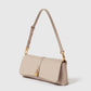 The Stella McCartney Ryder Pouchette Shoulder Bag is a beige luxury vegan accessory with a gold buckle and clasp, showcasing a short adjustable strap and a rectangular flap closure, presented against a plain white background.