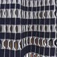 Close-up of the Simkhai Larken Midi Skirt featuring a navy and white textile pattern with interlocking loops, forming a net-like grid reminiscent of bold gingham knitwear.