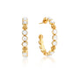 The Berry Gem Medium Hoop Earrings by Juliska Capucine De Wulf feature classic hoops with circular white stone inlays and delicate floral accents, displayed elegantly against a white background.