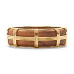 The Gaia Hinged Bangle by Juliska Capucine De Wulf features hand-carved wide teak wood adorned with raised gold accents in a rectangular grid pattern, where gold bands intersect elegantly across the surface.