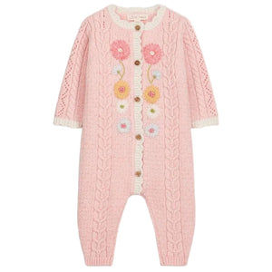 Introducing the Louise Misha Baby Girls’ Drilia Overalls: a pink knitted romper adorned with handmade floral embroidery, cable patterns, and wooden buttons. This charming jumpsuit features delicate white ruffle trim on the chest and cuffs, along with scalloped finishes for an extra-sweet touch.