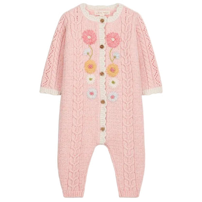 Introducing the Louise Misha Baby Girls’ Drilia Overalls: a pink knitted romper adorned with handmade floral embroidery, cable patterns, and wooden buttons. This charming jumpsuit features delicate white ruffle trim on the chest and cuffs, along with scalloped finishes for an extra-sweet touch.