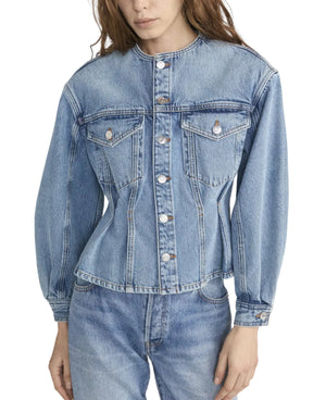A woman wears the Frame Nipped Collarless Jacket in light blue cotton denim with front buttons, paired with matching jeans, photographed from mid-thigh up.