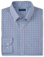 A neatly folded Peter Millar Fitch Performance Poplin Sport Shirt, featuring a blue checkered pattern, button-down collar, and long sleeves. Designed for ultimate comfort with two-way stretch fabric. The label reads "Peter Millar.