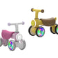 Sure! Here’s the rewritten sentence using your product data: Two Freddo Nature Navigator Balance Bikes for toddlers, each with four wheels—one in white and pink featuring a bunny face, and the other in yellow and brown with a bear face. Both interactive bikes have multicolored LED wheel lights to make playtime extra fun.