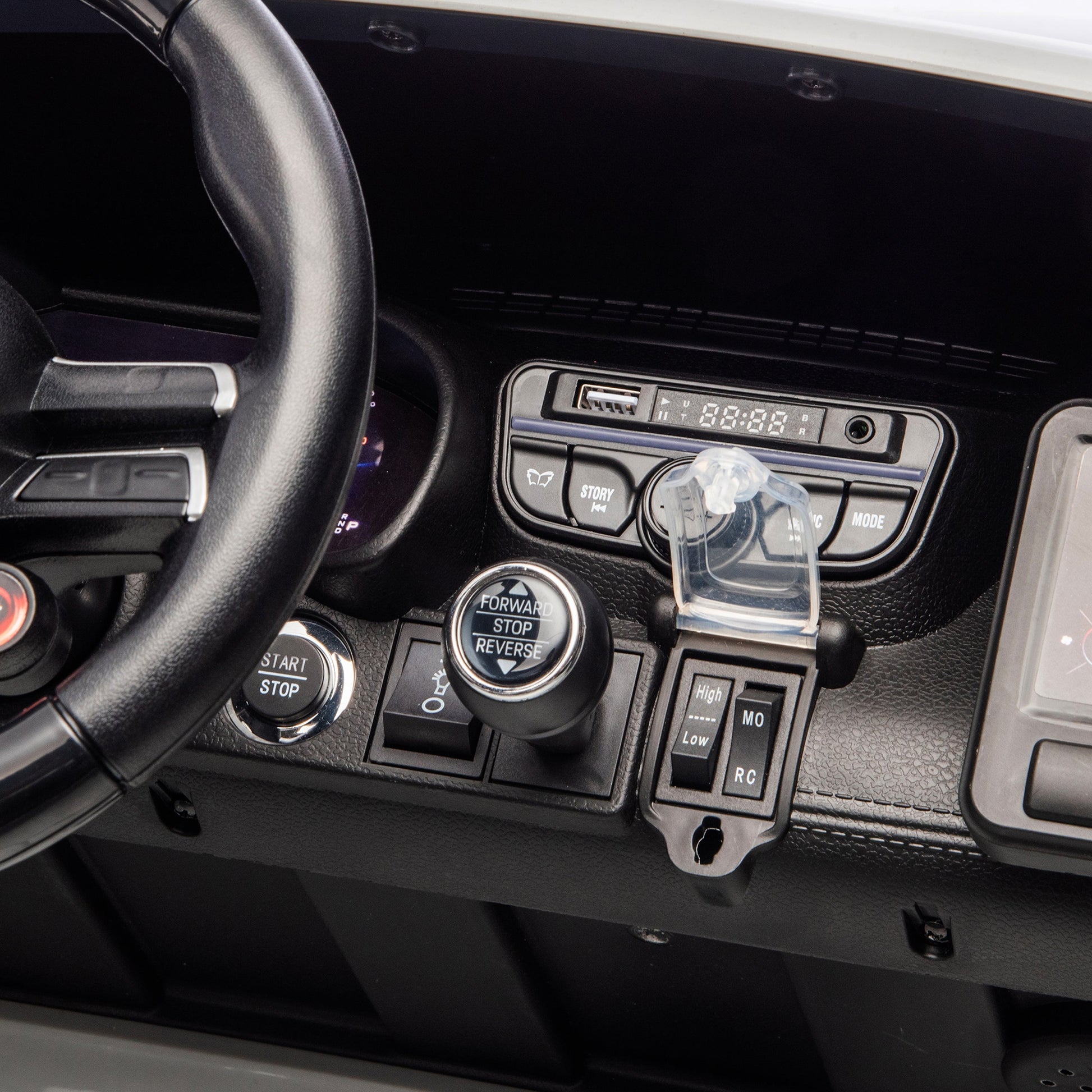 Close-up of the Freddo 24V Mercedes AMG GT63 Gray 2 Seater Ride-On dashboard, featuring a steering wheel, control buttons, display screen, and switches labeled with start, stop, forward, reverse, and mode options. This ride-on showcases the premium attention to detail you’d expect from this kids’ car.