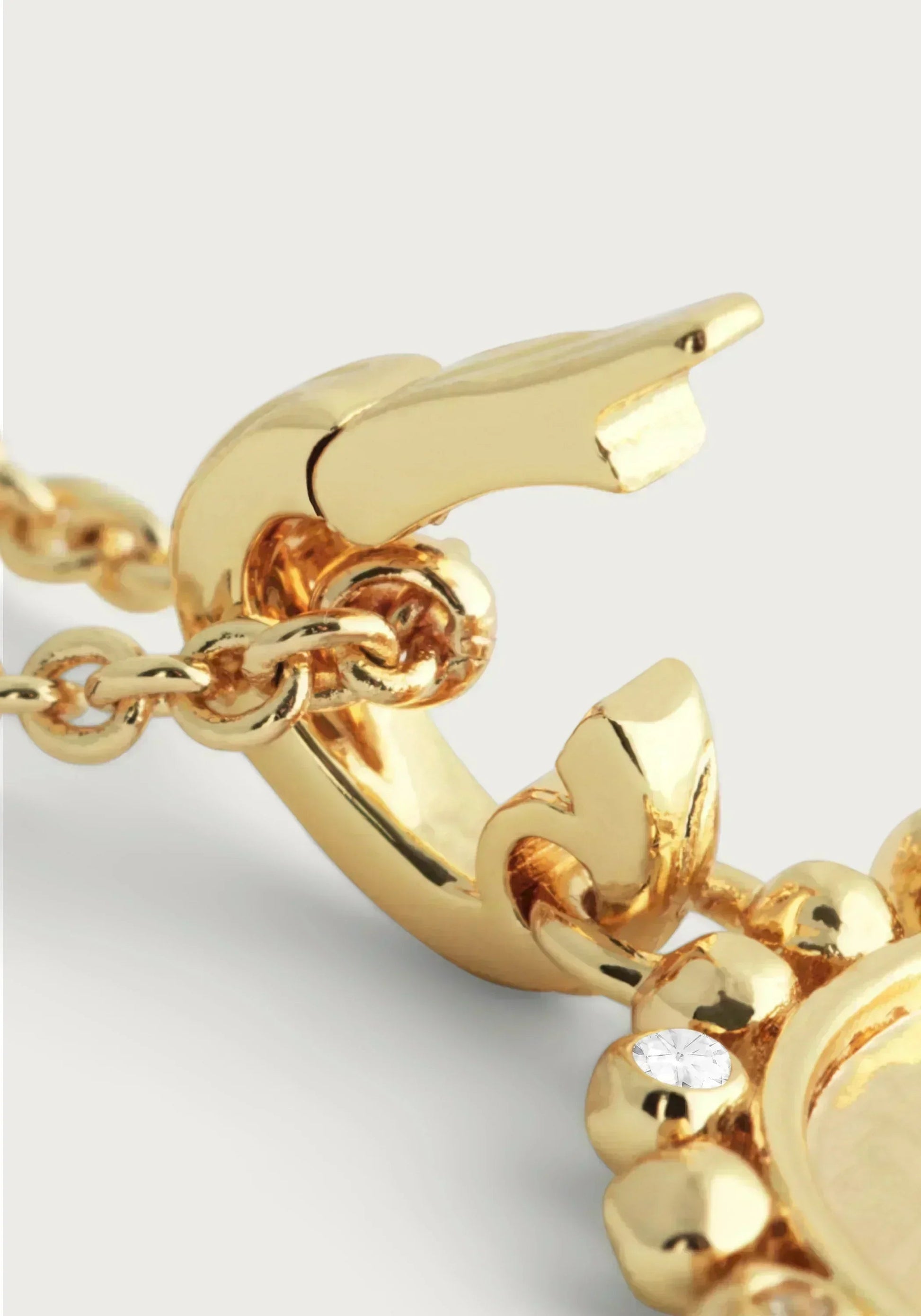 Close-up of the Anabel Aram Pegasus Gold Coin Charm, a gold chain necklace with a decorative pendant and small clear gemstone, featuring a mythical Pegasus-inspired design.