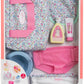 The Corolle Floral Changing Accessories Set includes a floral bag, bib, bottle, tube, underwear, bowl, and printed cloth—perfect for children aged 2 and up.