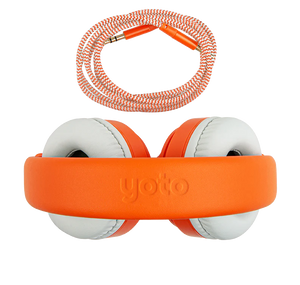 Introducing the Yoto, Headphones Orange by Yoto: orange and white over-ear headphones with the word "yoto" on the adjustable headband. An orange braided audio cable with gold connectors is shown above the headphones. The lightweight, durable construction includes kid-safe volume limiting for safe listening.
