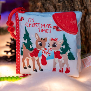 The Kids Preferred Rudolph Soft Book is a sensory baby activity toy with cartoon reindeer, trees, festive "IT'S CHRISTMAS TIME!!" text, and a wintry background—perfect for little ones.