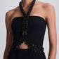 Simkhai Zoriel Gown in black, featuring a strapless column silhouette, an embellished halter neckline, and a beaded cutout detail at the midriff.
