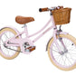 A pink Banwood Classic Children’s Bicycle with a wicker basket has a retro feel.