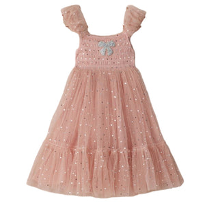 The Clara Dress by Noralee features a light pink smocked bodice, sleeveless design, ruffled shimmering tulle skirt with silver sequin accents, and a decorative silver bow on the chest, shown against a plain white background.