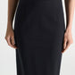 A person models the Dorothee Schumacher Emotional Essence Skirt, shown from shoulders to knees with arms relaxed at their sides against a plain background—a true work week essential.