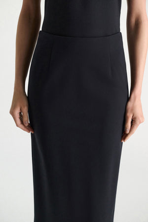 A person models the Dorothee Schumacher Emotional Essence Skirt, shown from shoulders to knees with arms relaxed at their sides against a plain background—a true work week essential.