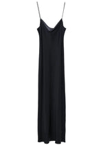 The Sense of Shine Dress by Dorothee Schumacher is a long black stretch silk-satin dress with thin spaghetti straps and a subtle waterfall neckline, shown against a plain white background.