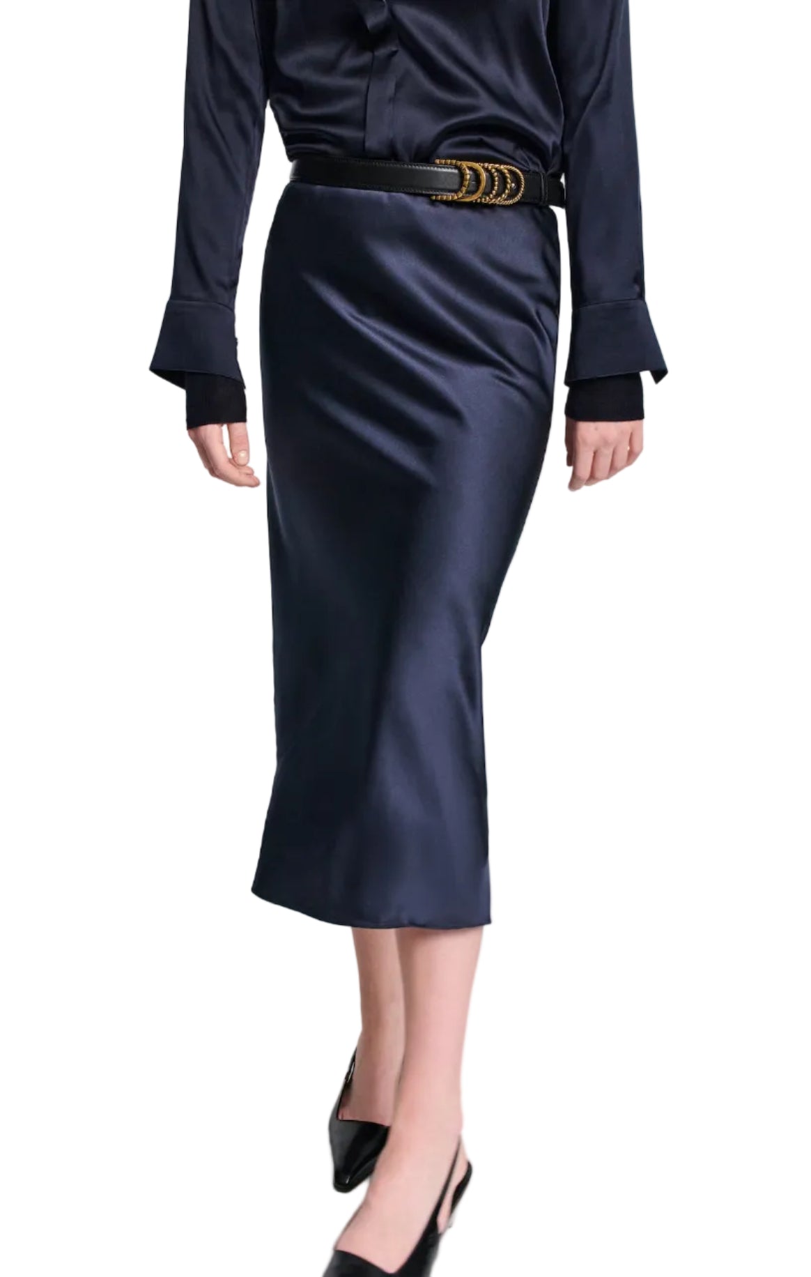 A model, shown from shoulders down, wears Dorothee Schumacher's Sense of Shine Skirt—a black stretch silk-satin midi with an elastic waistband—styled with a black satin blouse, black belt, and black heels.