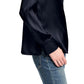 A person wears the Dorothee Schumacher Sense of Shine Blouse in fitted black stretch silk satin with a classic collar and blue jeans, standing with their left hand by their side against a white background.